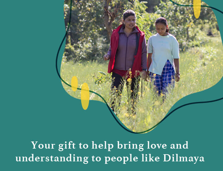 Dilmaya and a support person walking through grass with the caption 'Your gift to help bring love and understanding to people like Dilmaya'