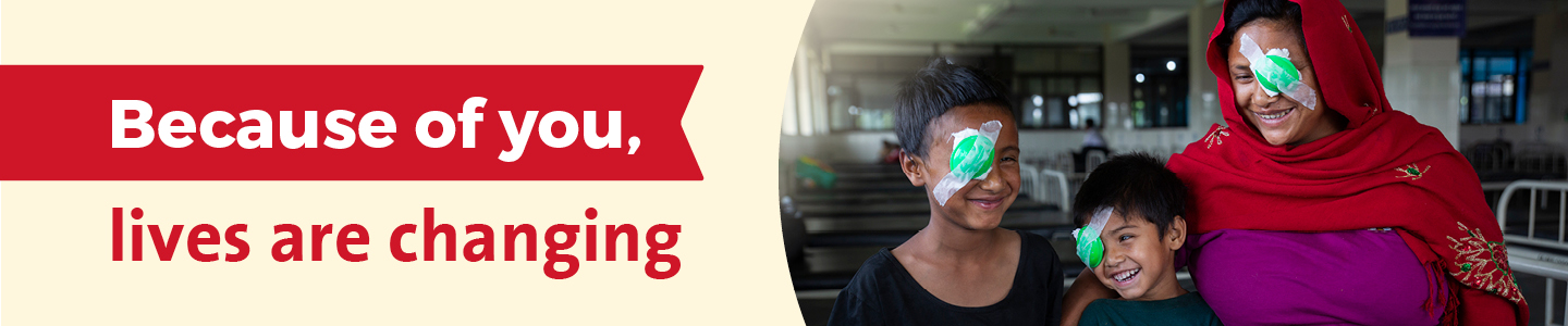 A mother and her children standing together with eye patches, accompanied by text that reads “Their beautiful, joyful smiles are all because of you!” with small decorative stars and shapes around them.