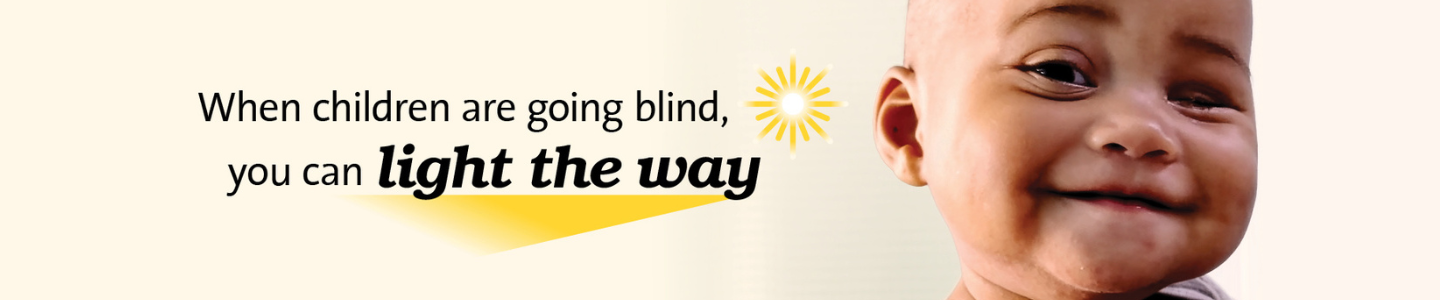 Text reads “When children are going blind, you can light the way,” accompanied by a stylized yellow sunburst graphic. On the right side, part of a child's head and ear is visible.